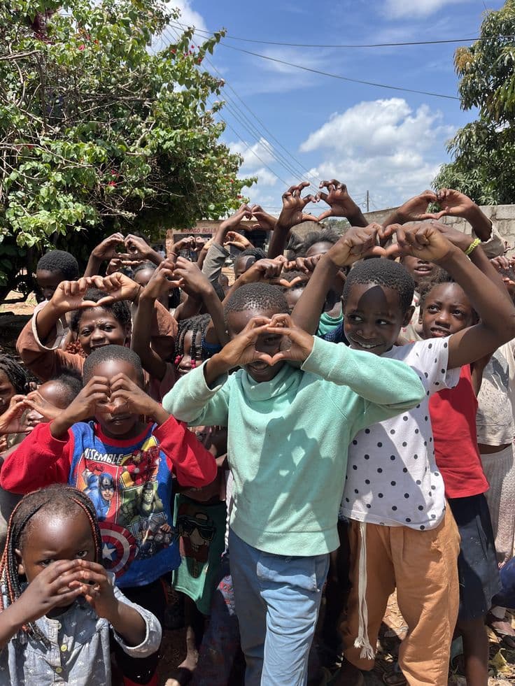 Children at a Ythirst school outreach making heart shapes with their hands